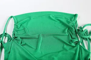 Detailed close-up of a green halter dress showing drawstring and fabric texture.