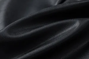 Macro view of high-quality black PU leather texture showing fine grain and soft sheen