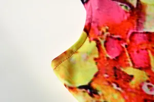 Macro view showing the high-quality stitching detail on a vibrant floral print dress