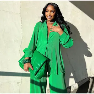 Vibrant green pleated two-piece set featuring loose long-sleeve shirt and trousers.