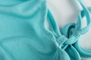 Close-up of light blue summer dress fabric showing detailed texture and strap design