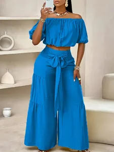 Ensemble chic haut court bleu à épaules dénudées et pantalon large avec ceinture à nœud
