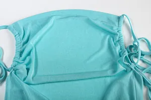 Close-up of turquoise halter dress featuring gathered drawstring neckline and soft fabric.