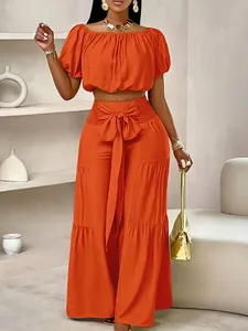 Ensemble chic orange deux pièces avec crop top épaules dénudées et pantalon large taille haute