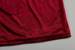 Nahaufnahme der Textur des hochwertigen roten Samtstoffes eines sexy Schlitzkleides