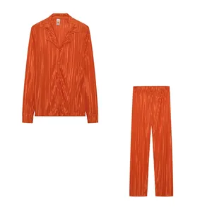 Two-piece plissé set featuring a long-sleeve button-down shirt and matching pleated pants