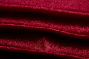 Makroansicht des luxuriösen tiefroten Samtstoffes mit weichem Glanz und eleganter Textur