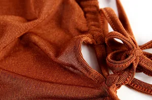 Detailed texture of brown knitted fabric with elegant tie-knot design for backless dress