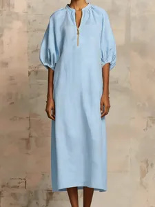 Close-up of light blue cotton linen dress with puff sleeves and zip V-neckline