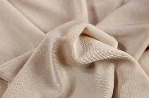 Close-up detail of the beige ribbed knit fabric showing soft texture and weave