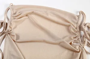 Close-up detail of high-quality beige gathered fabric texture on a backless halter dress