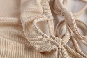 Macro view of the beige halter dress fabric texture and delicate lace-up strap details.