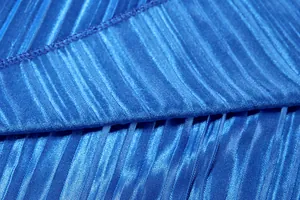 Macro view of shimmering blue pleated fabric showing fine texture and stitching details
