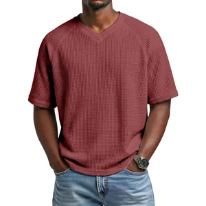 Macro view of burgundy waffle knit texture on a men's V-neck raglan sleeve T-shirt