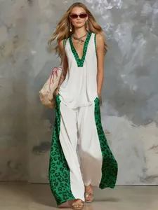 Close-up showing the green leopard print patchwork on the white sleeveless top and pants set