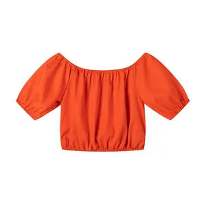 Vue détaillée d'un haut court orange vif à épaules dénudées et manches bouffantes.