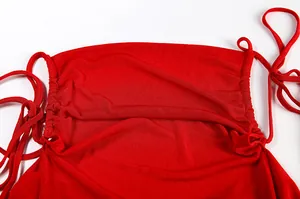 Close-up of ruched detail and side ties on a vibrant red sexy halter dress