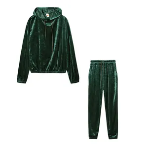 Completo sportivo due pezzi in velluto verde smeraldo con cappuccio su sfondo bianco puro