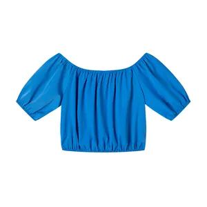 Détail à plat d'un haut court bleu à épaules dénudées et manches bouffantes.