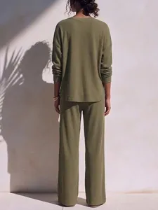 Back view of a women's olive green waffle knit two-piece lounge set in soft sunlight