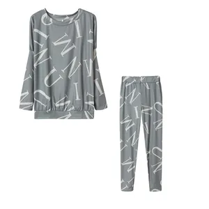 Gedetailleerd overzicht van grijze tweedelige loungewear-set met witte letterprint.