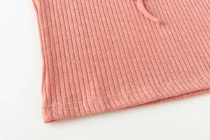 Detailed macro view showing the ribbed knit fabric texture of a pink casual hooded set