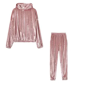 Dettaglio del set coordinato felpa con cappuccio e pantaloni in velluto rosa.