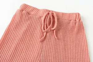 Close-up of the elastic waistband and drawstring on pink ribbed casual lounge pants.