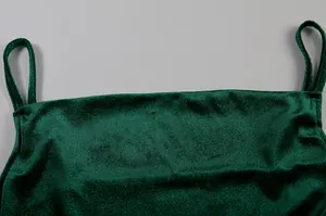 Nahaufnahme eines dunkelgrünen Samt-Camisole-Kleides zeigt weiche Stoffstruktur