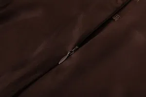 Κοντινό πλάνο κρυφού φερμουάρ υψηλής ποιότητας σε μια καφέ σατέν φούστα με μεταξένια υφή.