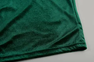 Detailansicht der hochwertigen Textur und Saumverarbeitung von grünem Samtstoff.