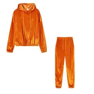 Dettaglio del set casual in velluto arancione brillante con felpa con cappuccio e pantaloni.