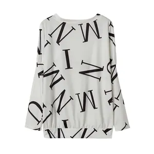 Detailweergave van casual dames-top met lange mouwen en opvallende zwarte letterprints