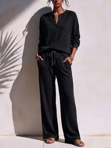 Full view of women's black waffle knit lounge set with henley top and wide-leg pants