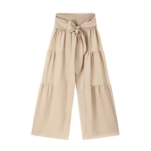 Pantalon beige à taille haute et jambes larges avec ceinture à nœud et détails à volants.