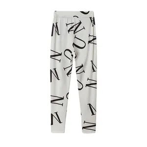 Detailweergave van damesleggings met gedurfde zwarte N-letterprint op wit textiel