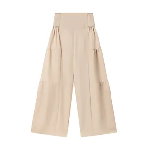 Détail de ce pantalon beige à taille haute et jambes larges avec volants étagés
