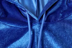 Vista dettagliata della morbida trama in velluto blu su una felpa con cappuccio casual
