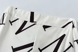 Gedetailleerde close-up van de elastische taille van een witte vrijetijdsbroek met letterprint