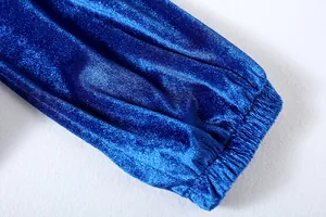 Dettaglio ravvicinato della morbida trama e del polsino elastico di una manica in velluto blu