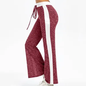 Side view of maroon wide-leg yoga pants with white stripes and drawstring at waist