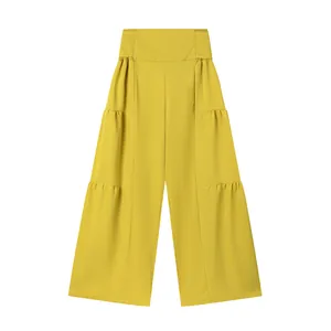 Détail du pantalon jaune à taille haute et jambe large avec design à étages