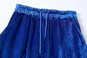 Dettaglio macro dell'elastico in vita e della coulisse blu di un pantalone in velluto