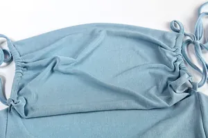 Close-up of blue halter dress with elegant draped neckline and shoulder tie details.
