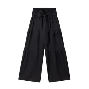 Vue détaillée du pantalon large noir à taille haute et nœud papillon