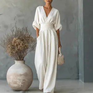 Elegant white V-neck jumpsuit with a cinched waist and wide-leg silhouette for women