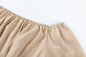 Détail de la taille élastiquée froncée sur un pantalon beige large