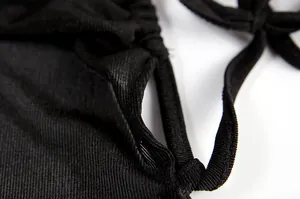 Close-up macro view of the black ribbed fabric texture and drawstring tie on a maxi dress