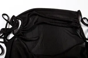 Detail of black halter dress showing fabric texture and adjustable ties