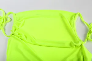 Close-up view of vibrant neon yellow halter neckline with soft pleated fabric texture